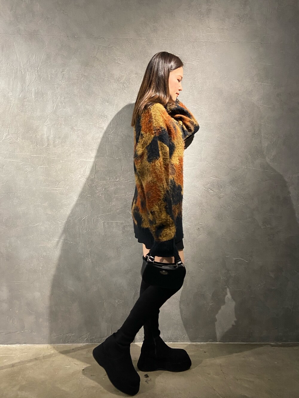 その他のニット/セーター、ブラック系のブーツ、ブラック系のハンドバッグを着用したレディースの秋コーディネートの2枚目の写真