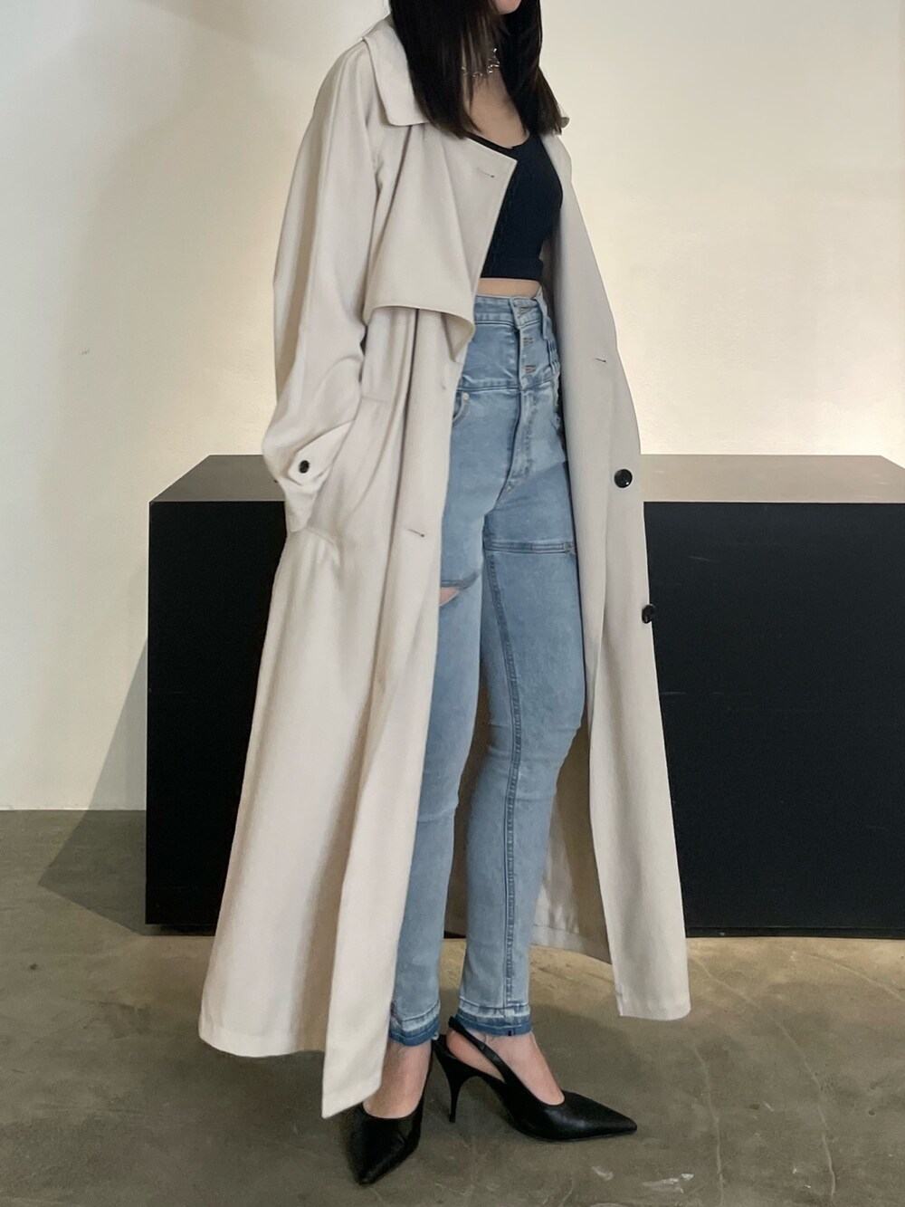 グリーン系のトレンチコート、ブラック系のパンプス、ブルー系のデニムパンツを着用したレディースの冬コーディネートの2枚目の写真