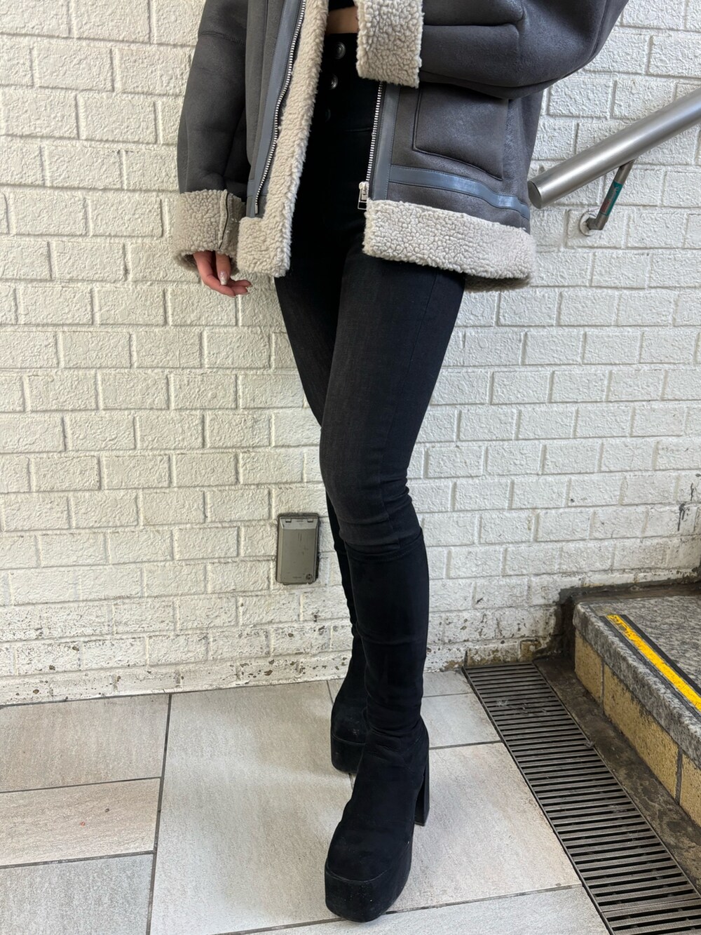 グレー系のムートンコート、ブラック系のデニムパンツ、その他のブーツを着用したレディースの秋コーディネートの8枚目の写真