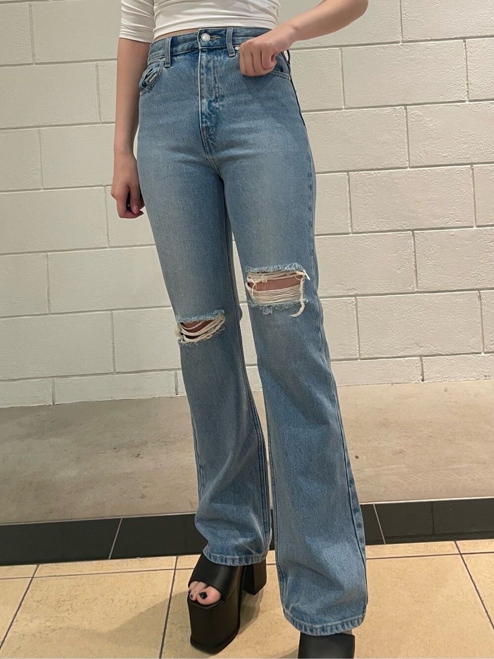 ブラック系のサンダル、ブルー系のデニムパンツ、ホワイト系のTシャツ/カットソーを着用したレディースの春コーディネートの4枚目の写真