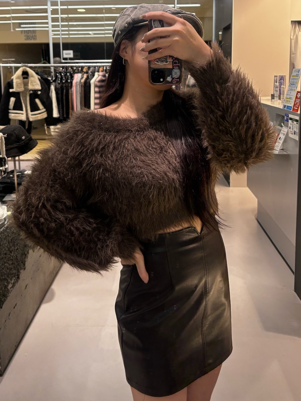 ブラック系のブーツ、ブラック系のスカート、ブラウン系のニット/セーターを着用したレディースの冬コーディネートの3枚目の写真