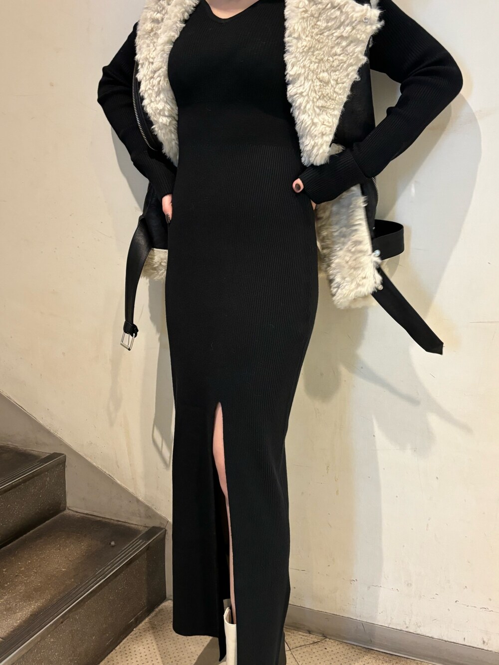 ブラック系のムートンコート、ブラック系のワンピース、ホワイト系のブーツを着用したレディースの秋コーディネートの7枚目の写真