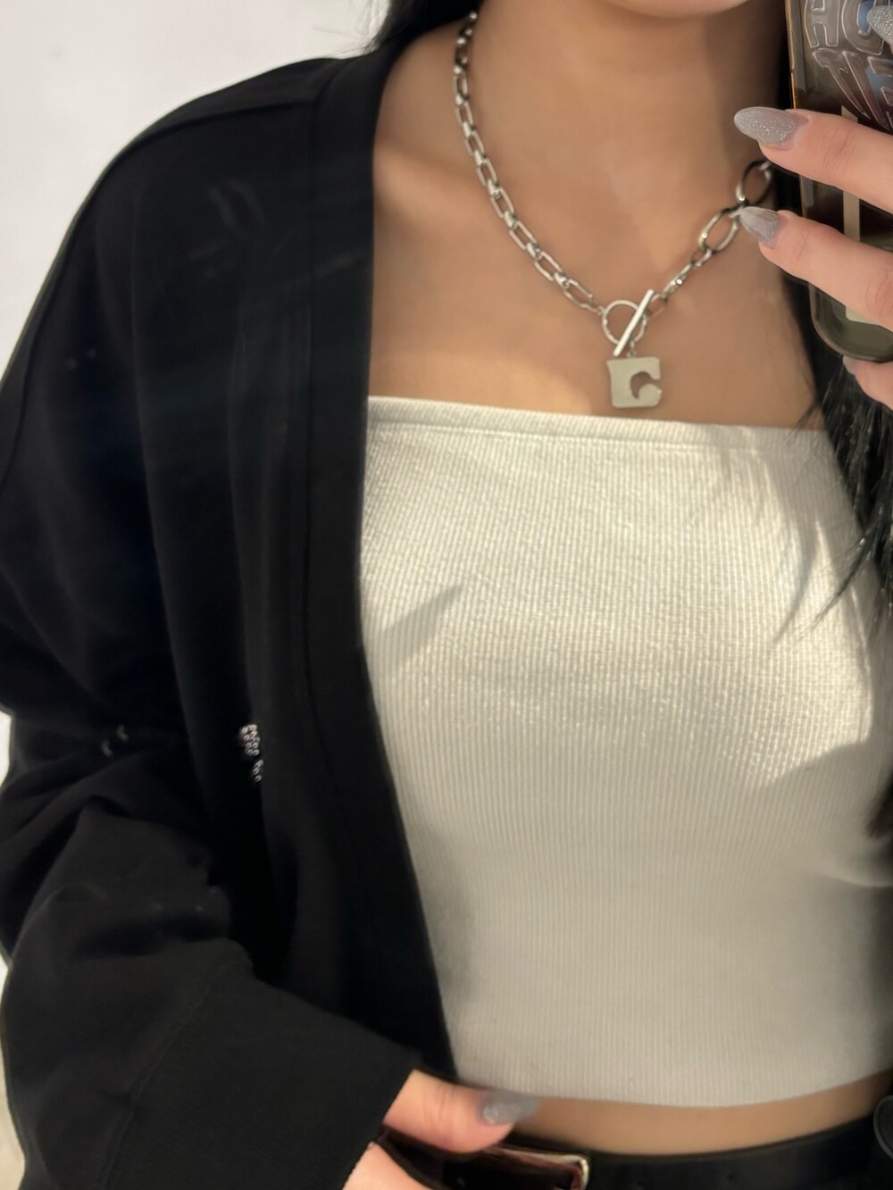 ブラック系のスカート、ブラック系のカーディガン/ボレロ、ブラック系のキャミソールを着用したレディースの春コーディネートの5枚目の写真