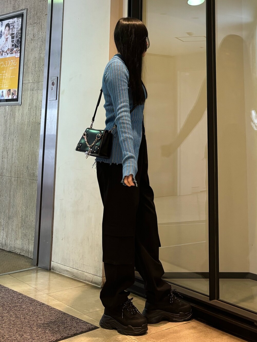 ブラック系のスニーカー、ブルー系のニット/セーター、ブラック系のその他パンツを着用したレディースの冬コーディネートの2枚目の写真