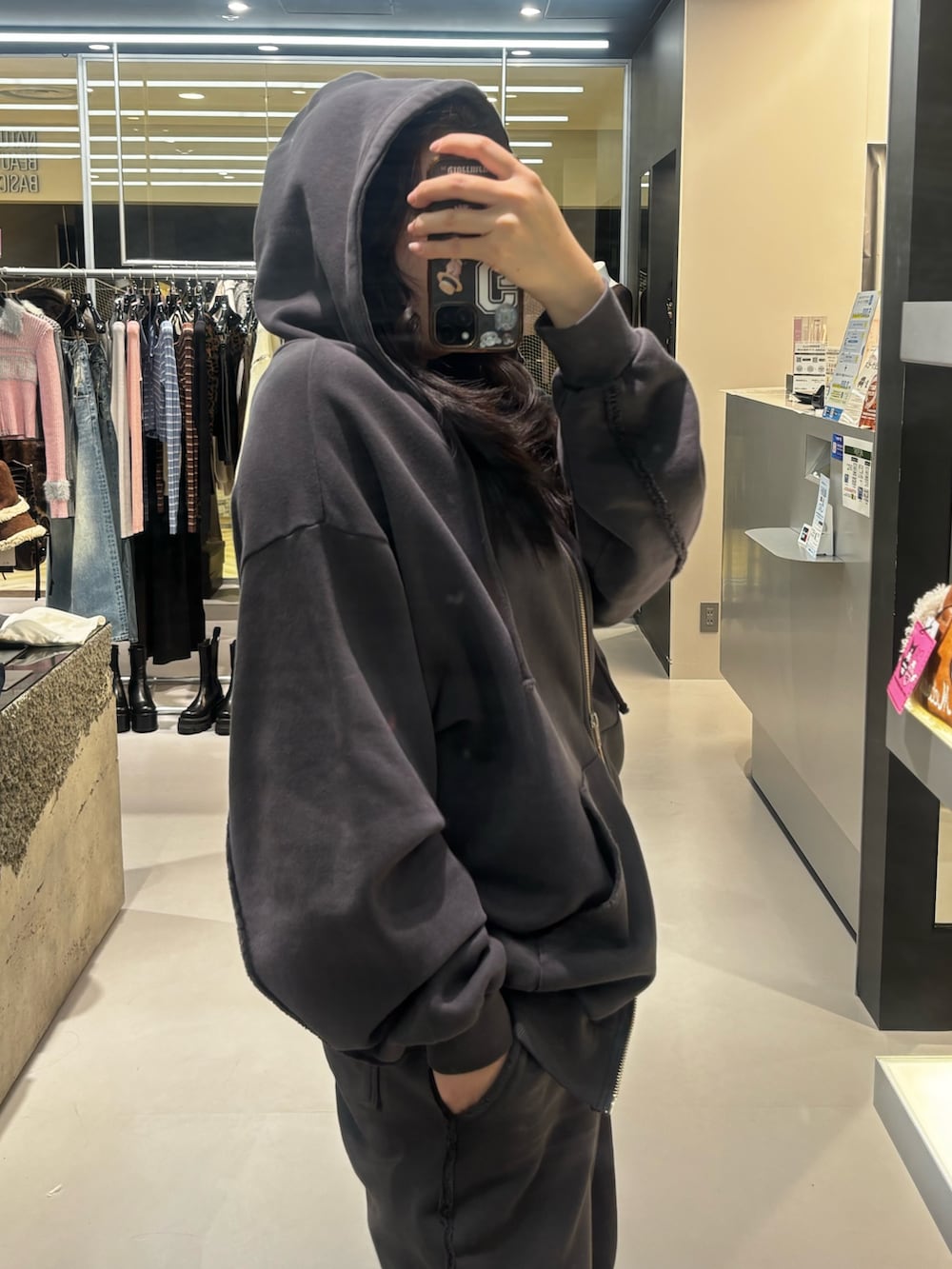 ブラック系のブーツ、グレー系のスウェットパンツ、グレー系のパーカーを着用したレディースの冬コーディネートの4枚目の写真