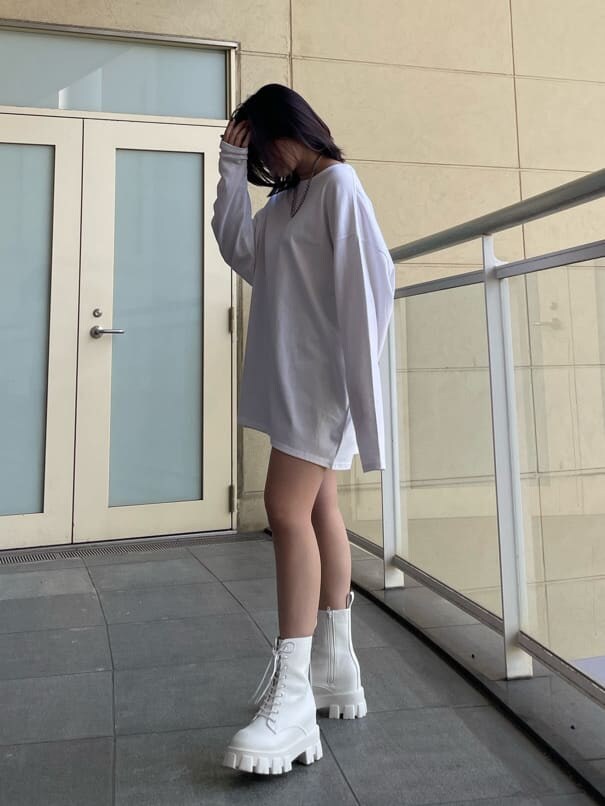 ホワイト系のTシャツ/カットソー、ホワイト系のブーツ、ブラック系のスカートを着用したレディースの春コーディネートの3枚目の写真