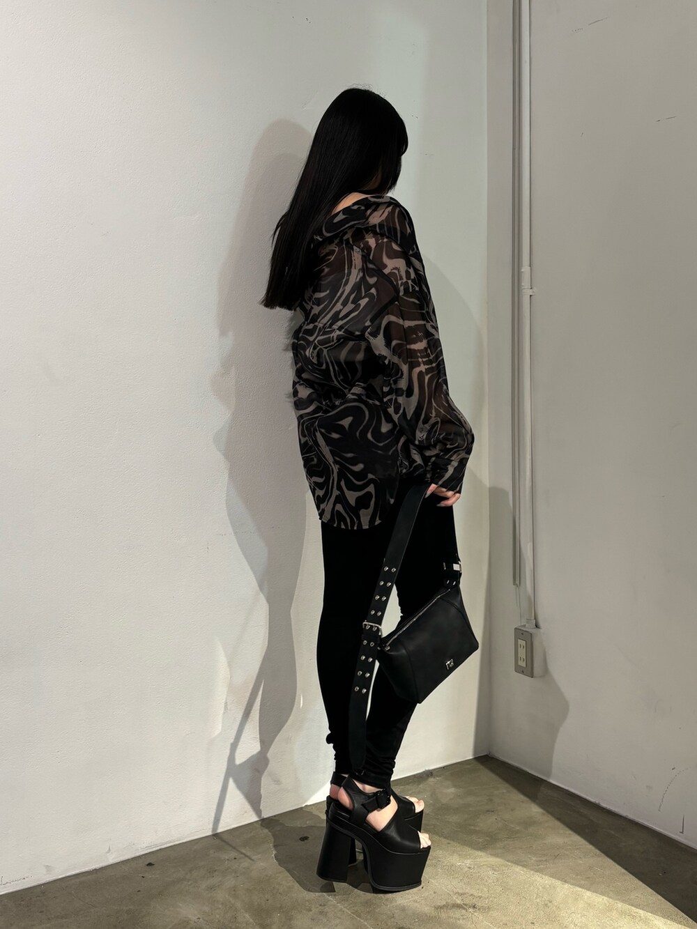 ブラック系のデニムパンツ、ベージュ系のシャツ/ブラウス、ブラック系のショルダーバッグを着用したレディースの春コーディネートの2枚目の写真