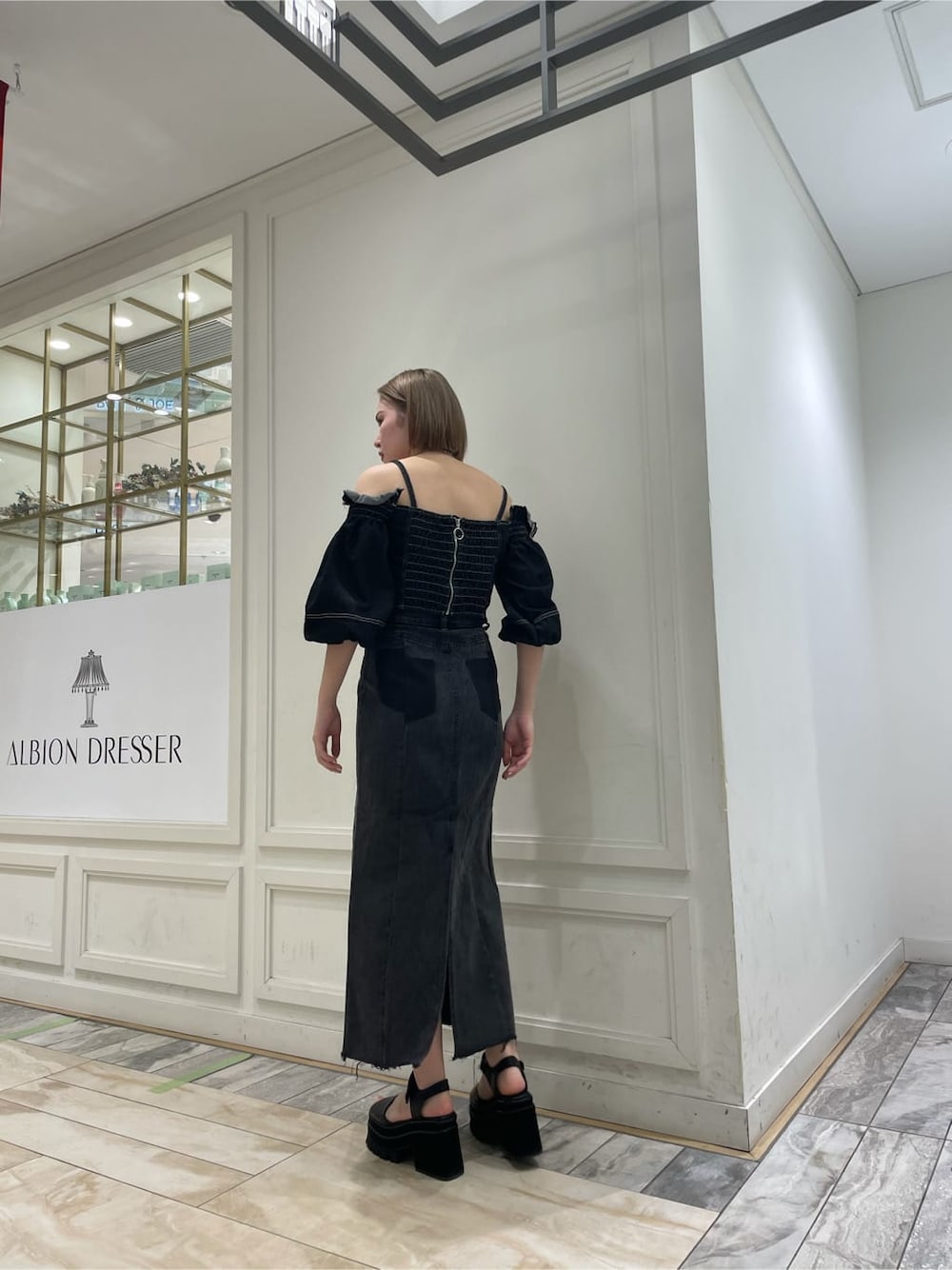 ブラック系のデニムスカート、ブラック系のシャツ/ブラウスを着用したレディースの夏コーディネートの2枚目の写真