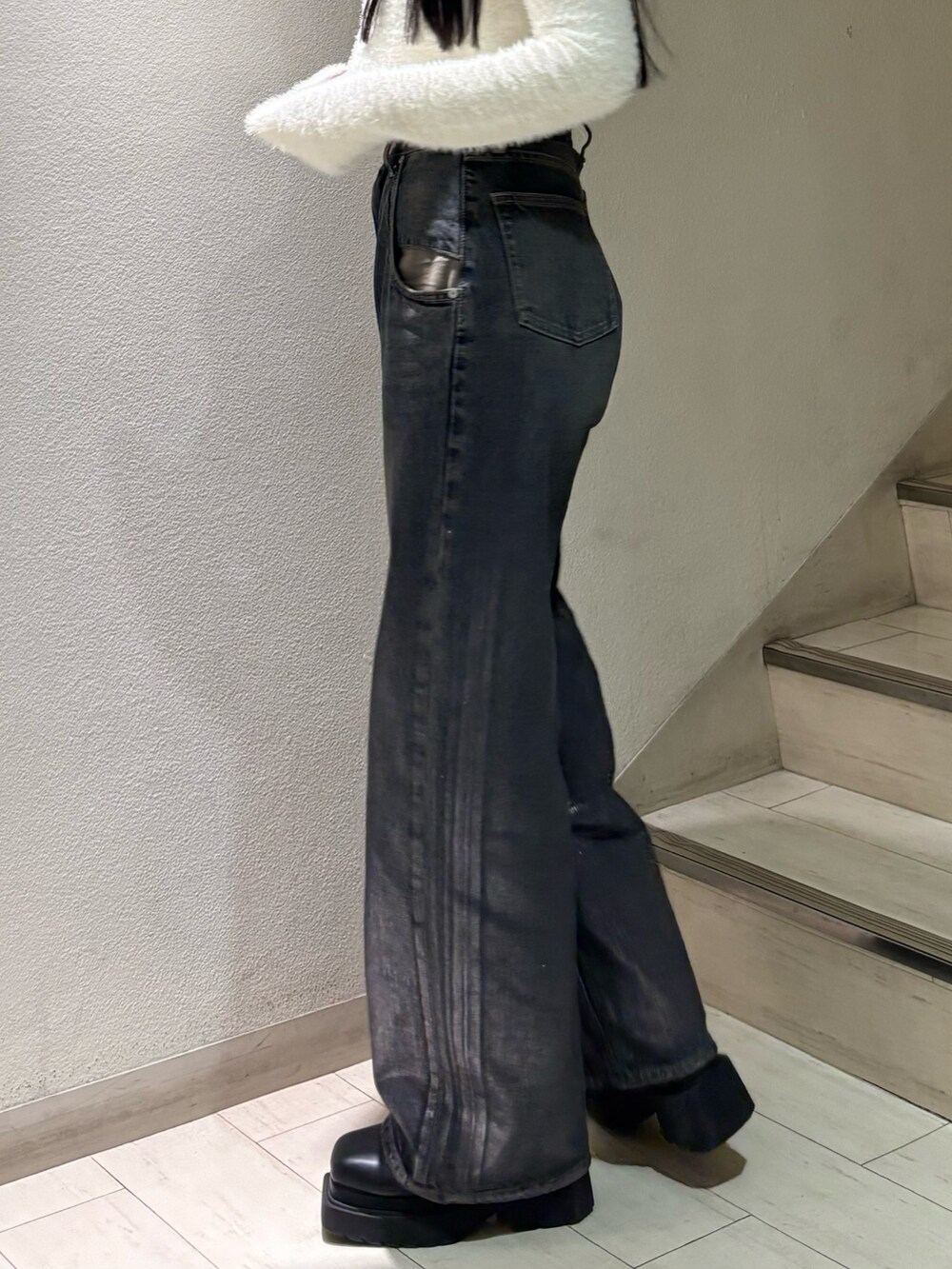 ホワイト系のニット/セーター、ブルー系のデニムパンツ、ブラック系のブーツを着用したレディースの秋コーディネートの6枚目の写真