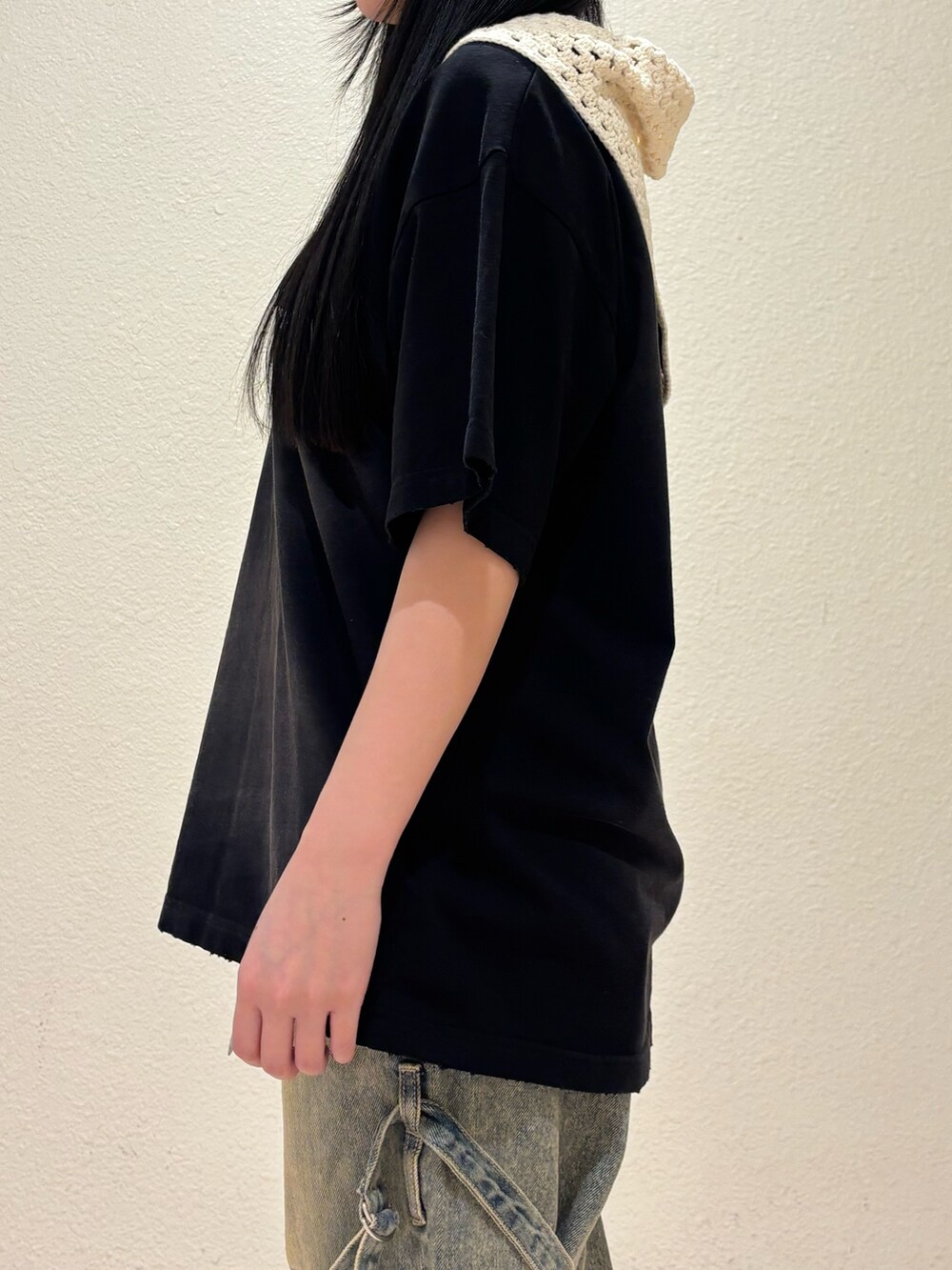 ブラック系のスニーカー、ベージュ系のデニムパンツ、ブラック系のTシャツ/カットソーを着用したレディースの春コーディネートの5枚目の写真