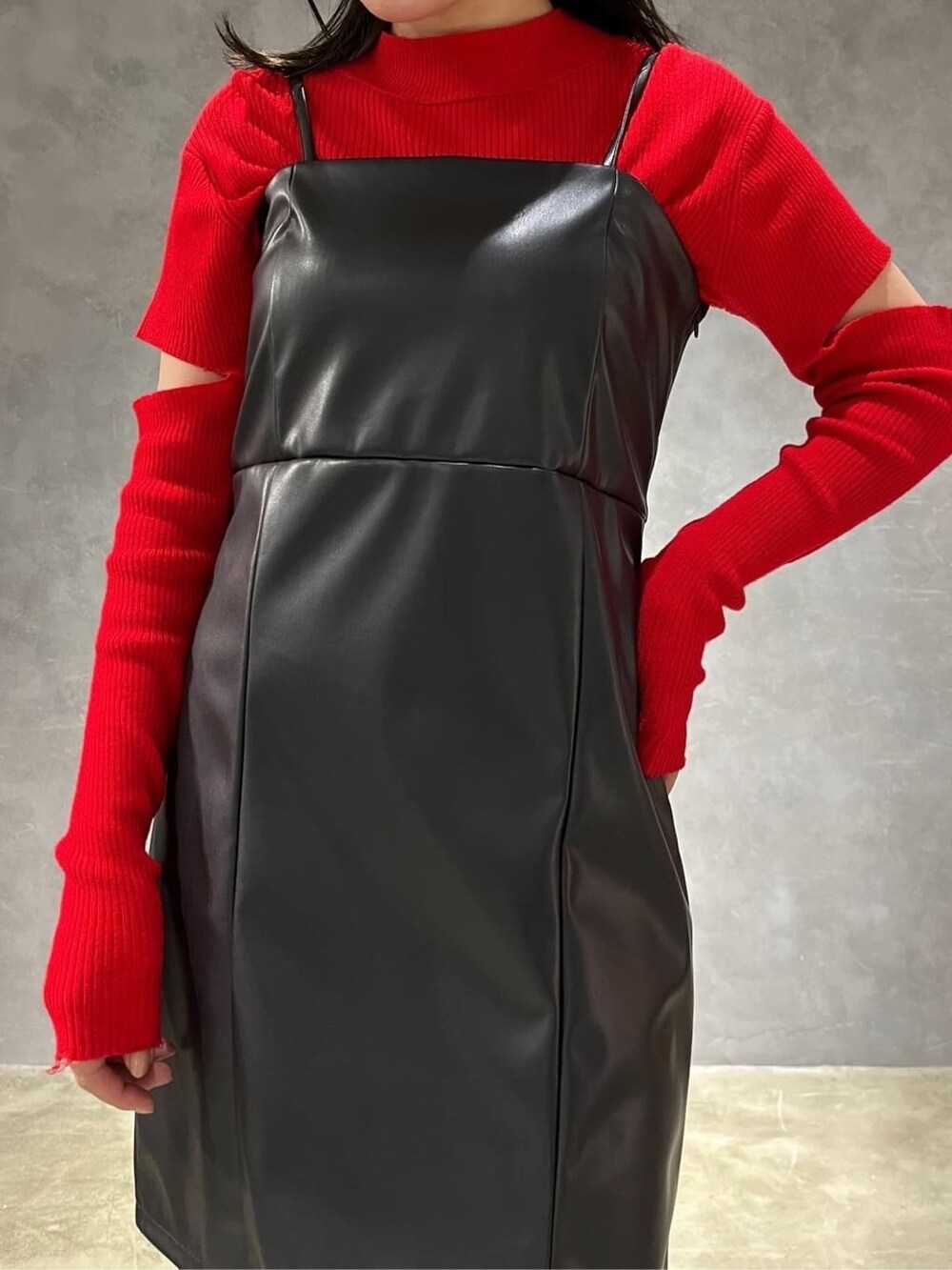 ブラック系のワンピース、レッド系のニット/セーター、ブラック系のブーツを着用したレディースの秋コーディネートの4枚目の写真