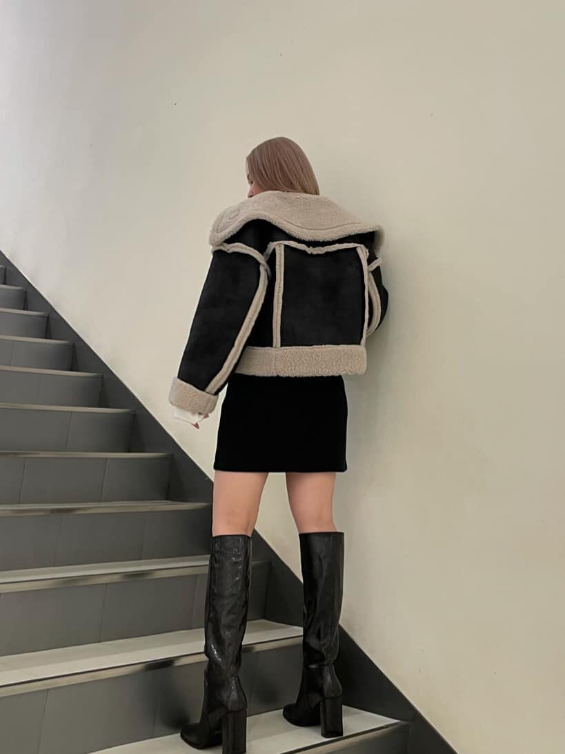 その他のブーツ、その他のムートンコート、ブラック系のスカートを着用したレディースの秋コーディネートの2枚目の写真