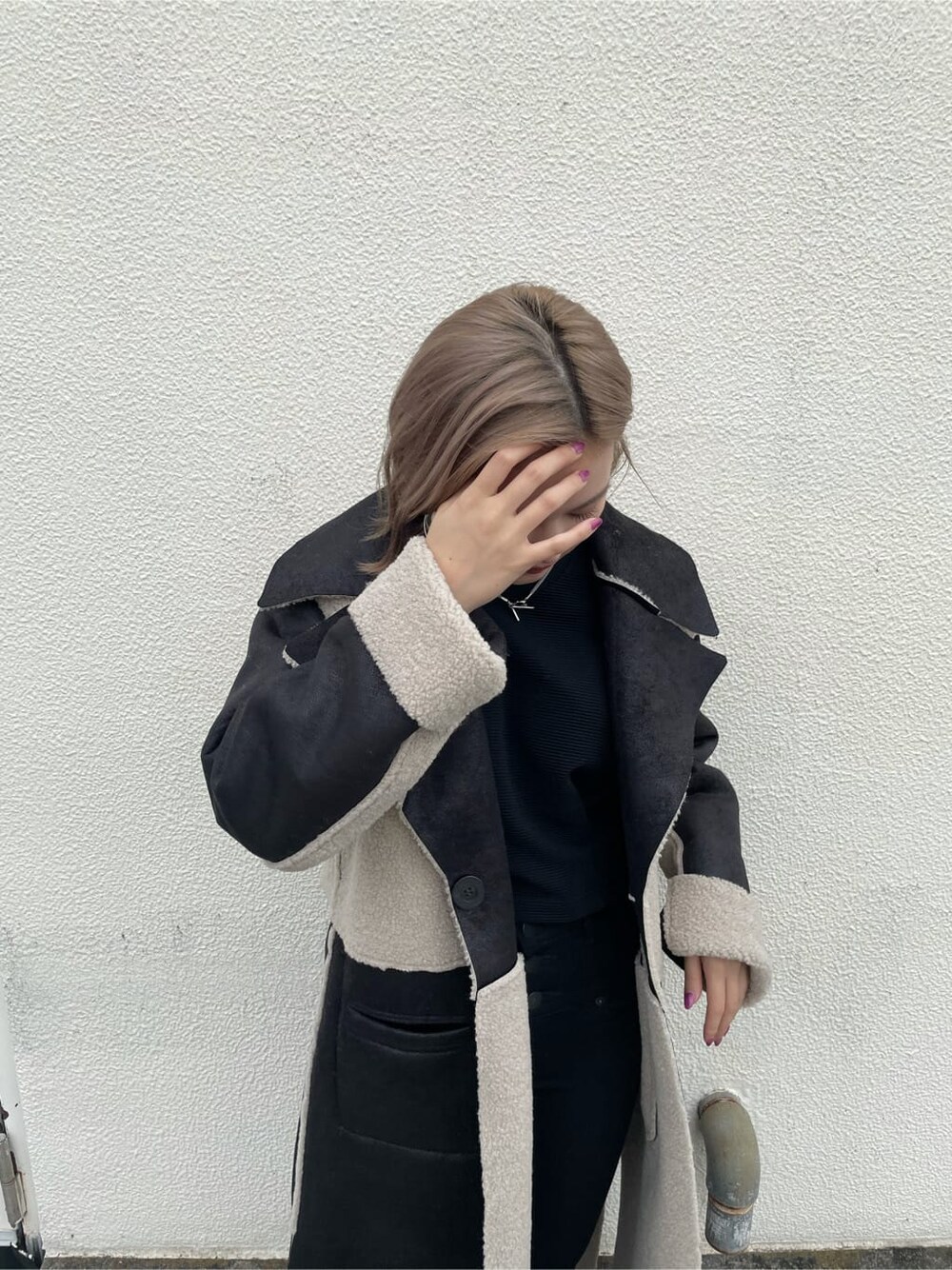 ブラック系のTシャツ/カットソー、ブラック系のデニムパンツ、ブラック系のムートンコートを着用したレディースの秋コーディネートの3枚目の写真