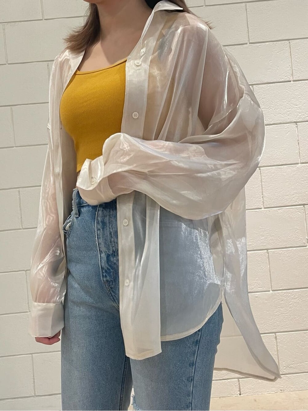 ブラック系のサンダル、ホワイト系のシャツ/ブラウス、ブルー系のデニムパンツを着用したレディースの春コーディネートの4枚目の写真