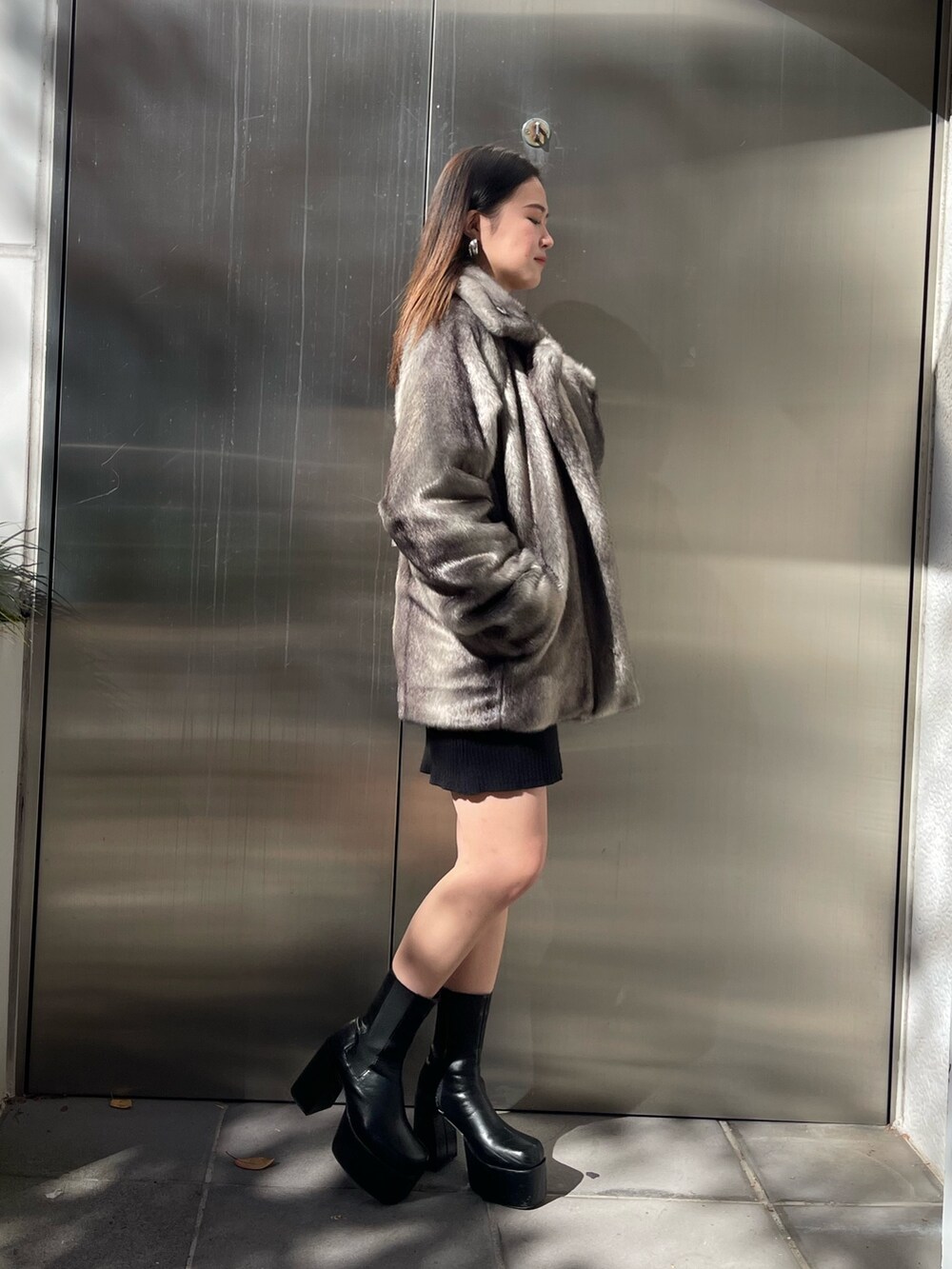 グレー系のその他アウター、ブラック系のワンピース、ブラック系のブーツを着用したレディースの秋コーディネートの2枚目の写真