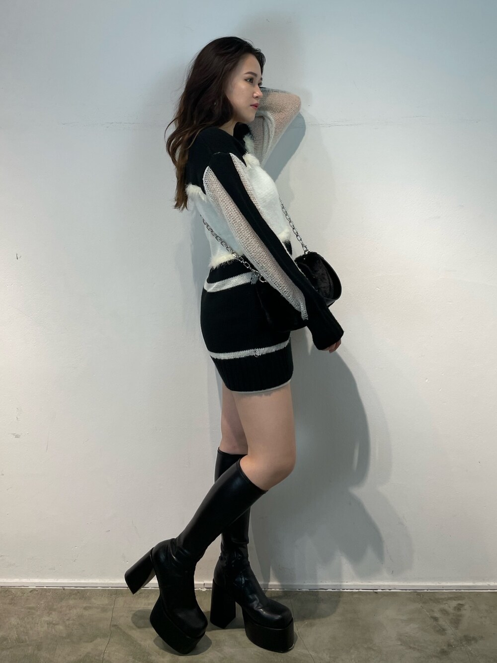 その他のブーツ、その他のニット/セーター、ブラック系のハンドバッグを着用したレディースの夏コーディネートの3枚目の写真