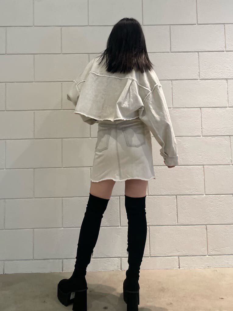 ホワイト系のデニムジャケット、ホワイト系のタンクトップ、ブラック系のブーツを着用したレディースの夏コーディネートの3枚目の写真