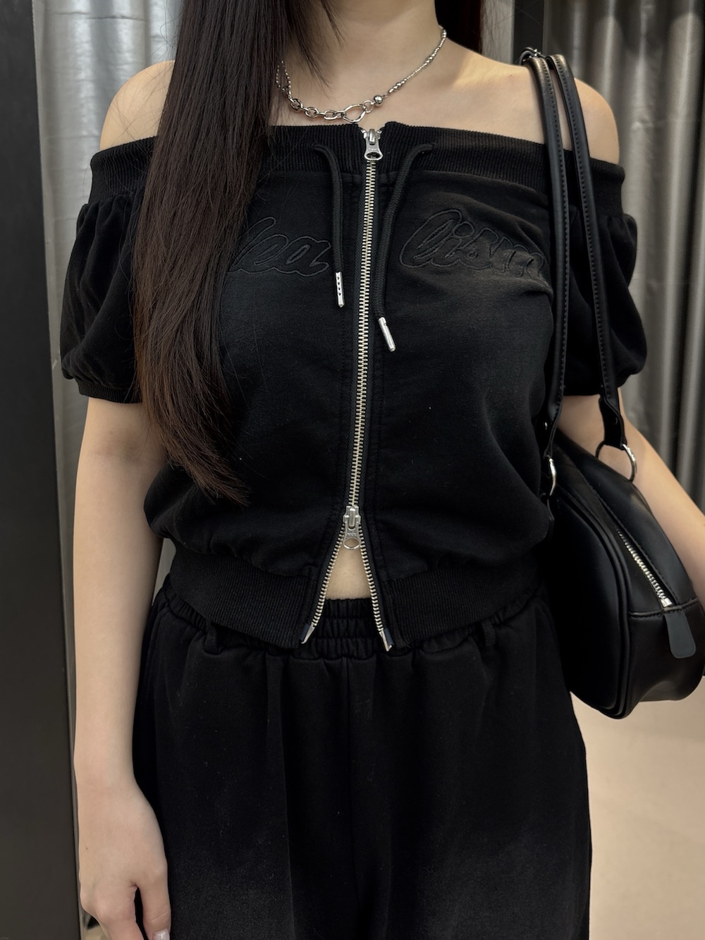 ブラック系のサンダル、ブラック系のスウェットパンツ、ホワイト系のハンドバッグを着用したレディースの夏コーディネートの4枚目の写真