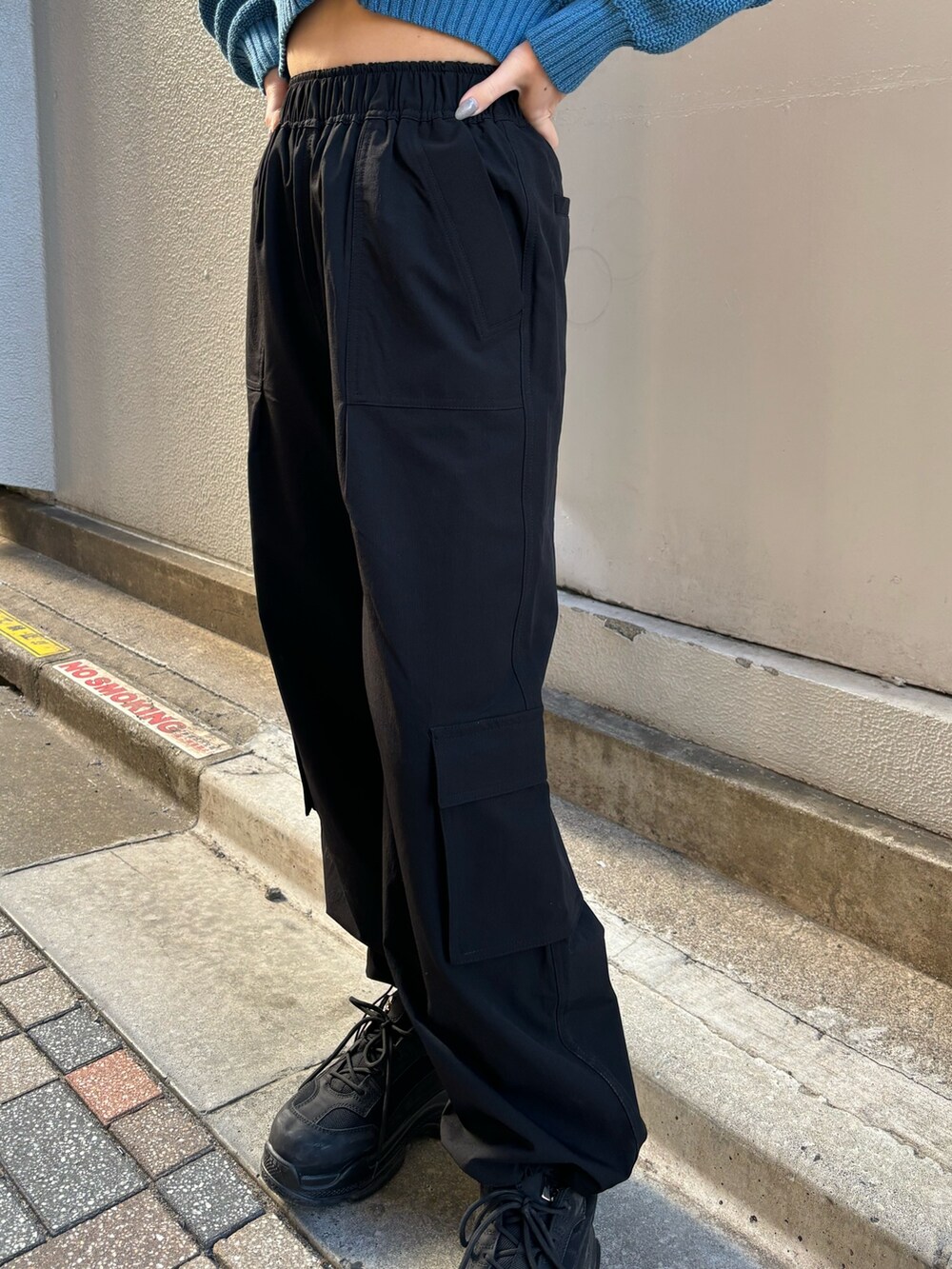 ブルー系のニット/セーター、ブラック系のスニーカー、ブラック系のその他パンツを着用したレディースの冬コーディネートの6枚目の写真