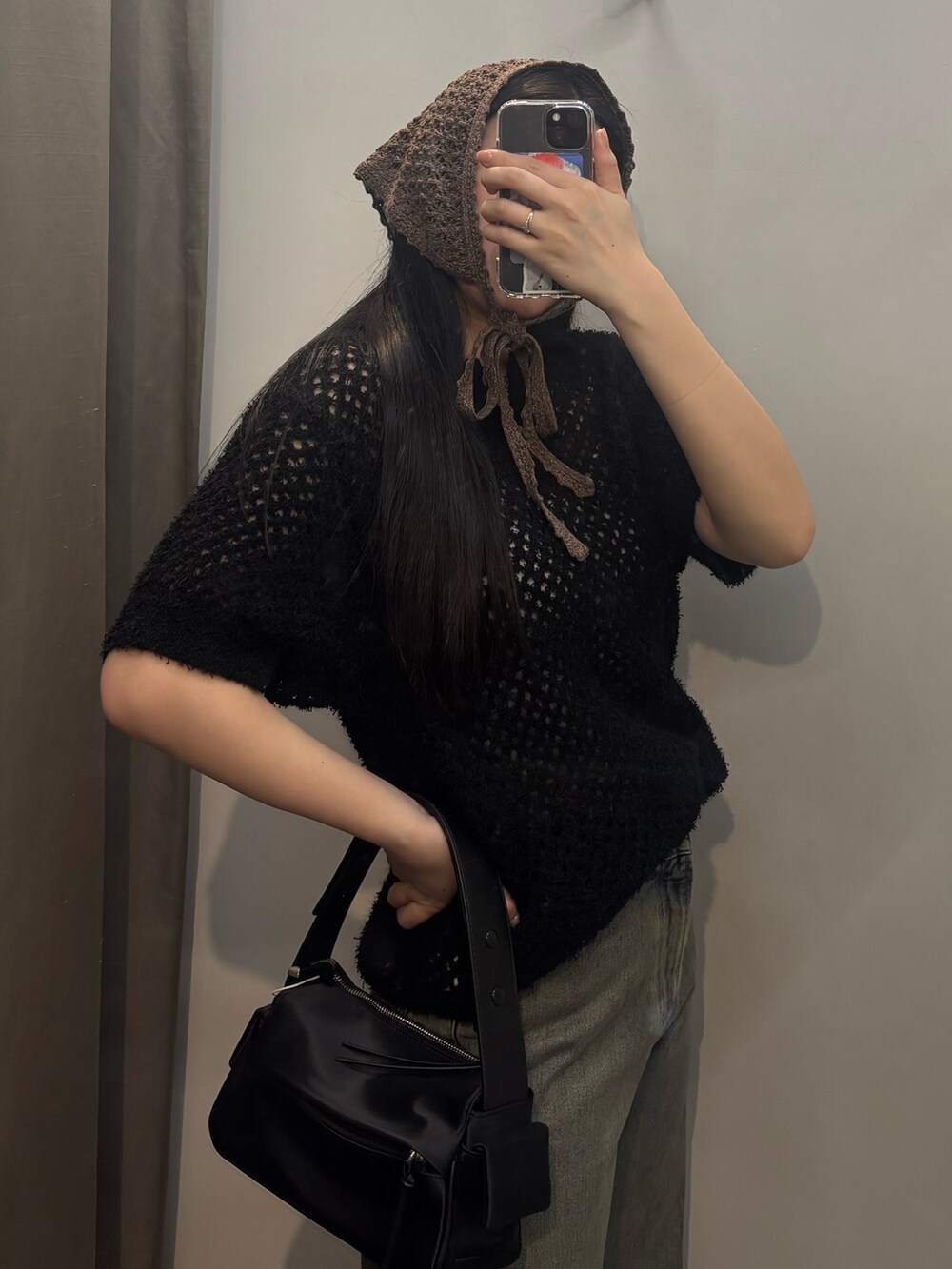 シルバー系のスニーカー、ブルー系のデニムパンツ、ブラック系のシャツ/ブラウスを着用したレディースの春コーディネートの4枚目の写真