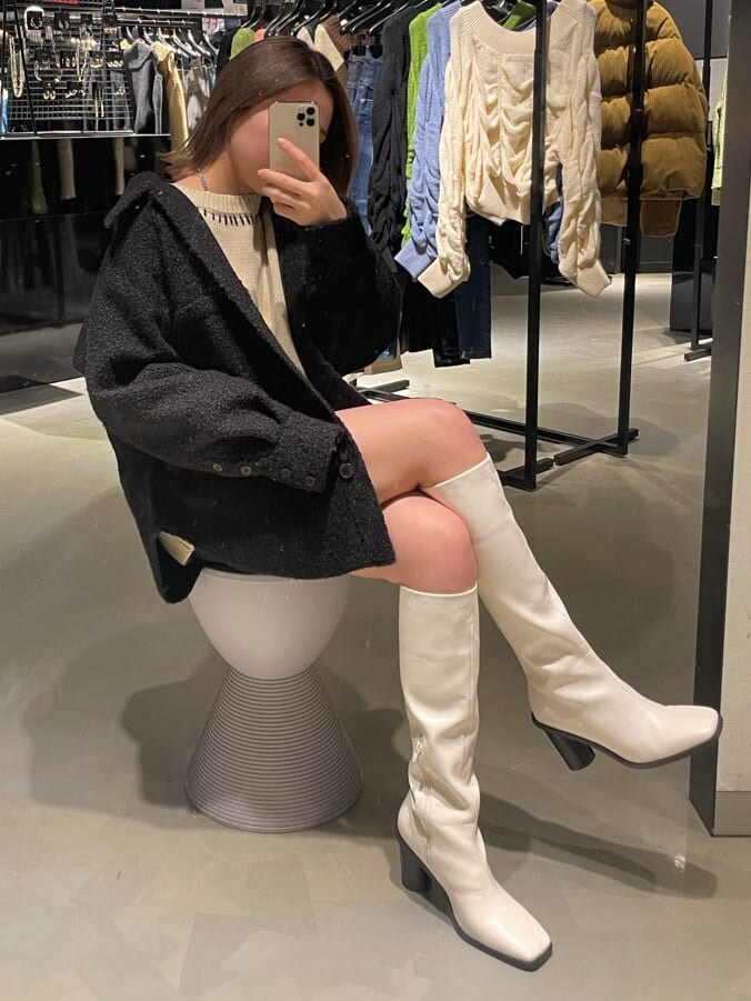 ブラック系のブルゾン、ホワイト系のブーツ、ホワイト系のニット/セーターを着用したレディースの冬コーディネートの9枚目の写真