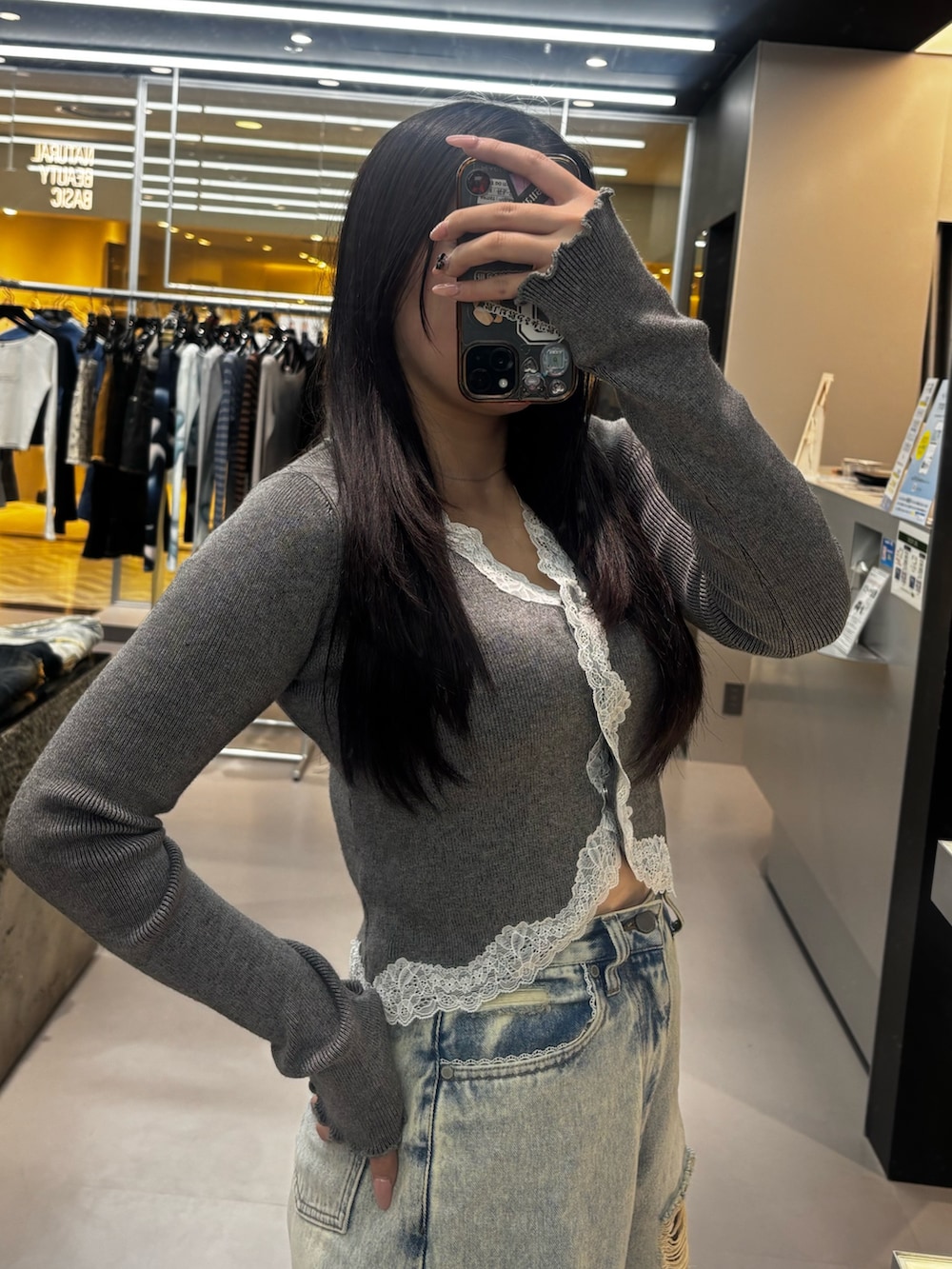 ブラック系のブーツ、ブルー系のデニムパンツ、グレー系のニット/セーターを着用したレディースの春コーディネートの4枚目の写真