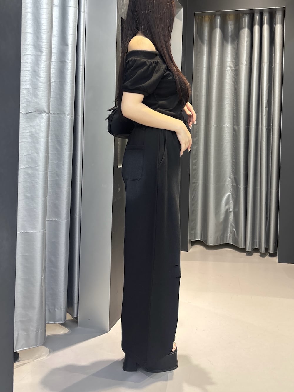 ブラック系のサンダル、ブラック系のスウェットパンツ、ホワイト系のハンドバッグを着用したレディースの夏コーディネートの3枚目の写真