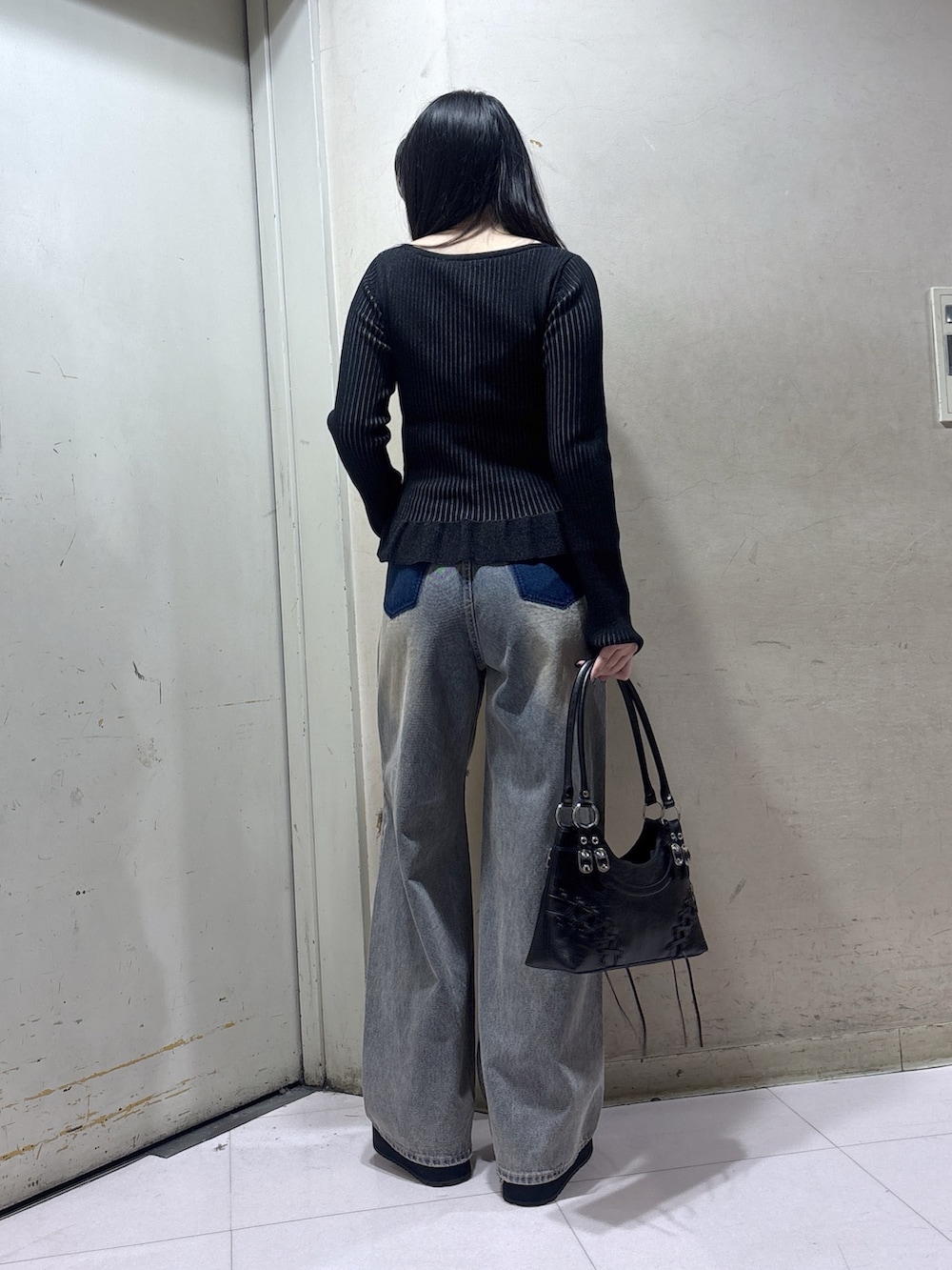 ブラック系のスリッポン、ブルー系のデニムパンツ、ブラック系のニット/セーターを着用したレディースの秋コーディネートの2枚目の写真