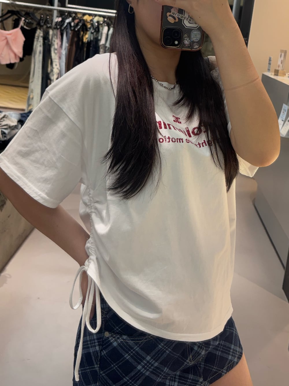 ブラック系のスニーカー、ホワイト系のTシャツ/カットソー、ブルー系のスカートを着用したレディースの春コーディネートの4枚目の写真