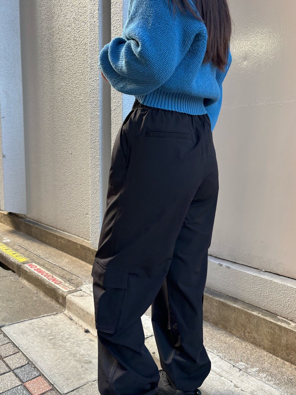 ブルー系のニット/セーター、ブラック系のスニーカー、ブラック系のその他パンツを着用したレディースの冬コーディネートの5枚目の写真