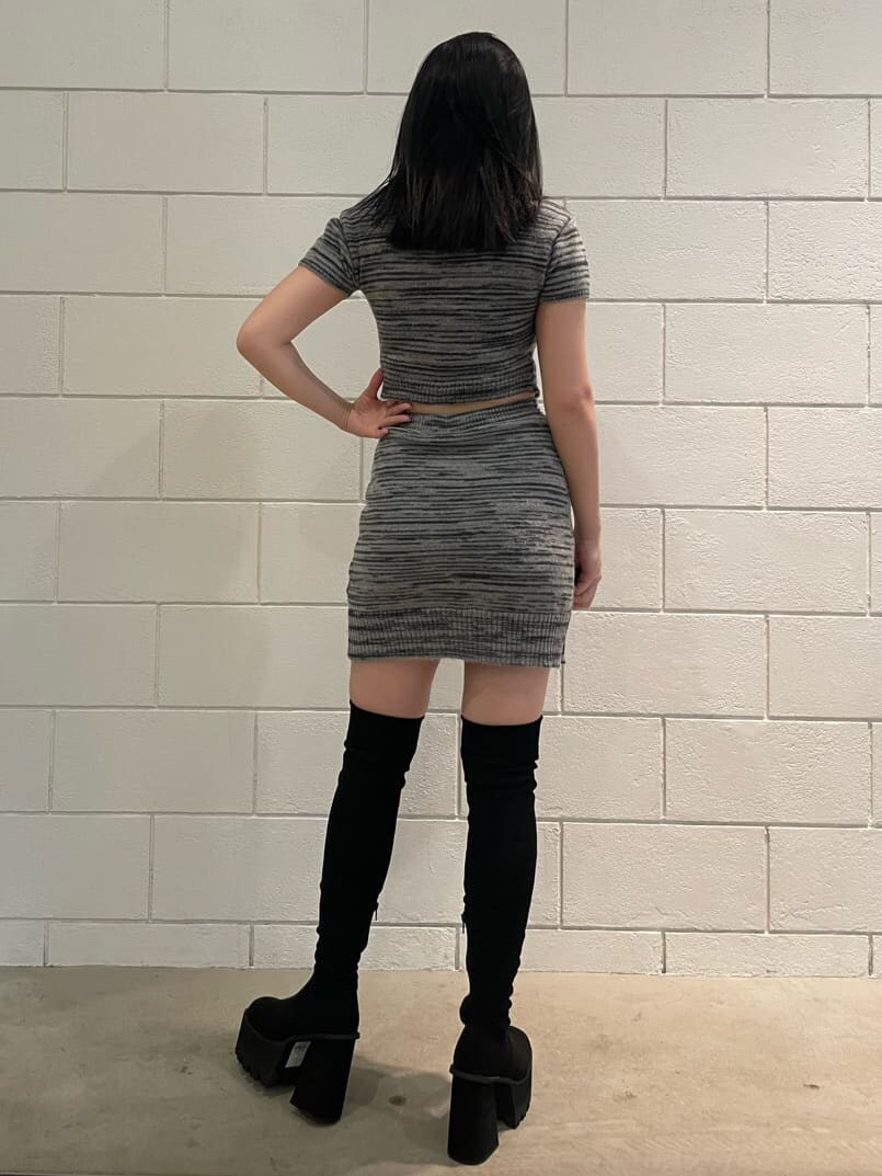 ブラック系のスカート、ブラック系のニット/セーター、ブラック系のブーツを着用したレディースの夏コーディネートの2枚目の写真