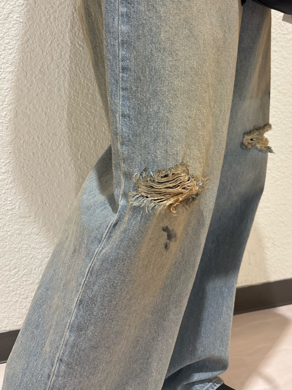 ブラック系のブーツ、ブラック系のハンドバッグ、ブルー系のデニムパンツを着用したレディースの春コーディネートの9枚目の写真