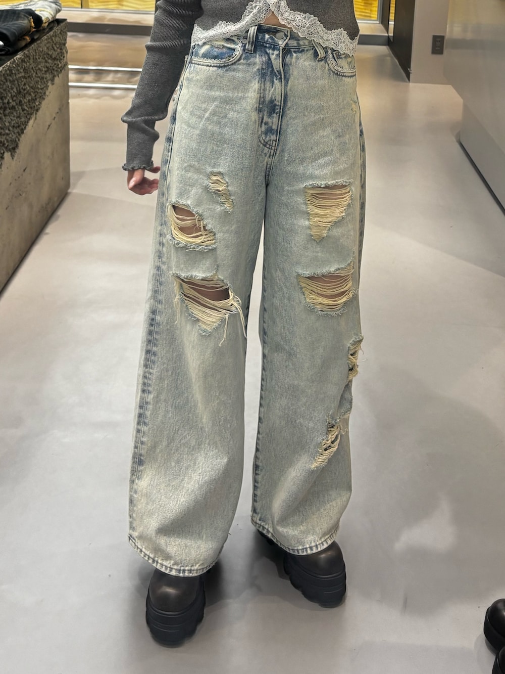 ブラック系のブーツ、ブルー系のデニムパンツ、グレー系のニット/セーターを着用したレディースの春コーディネートの5枚目の写真