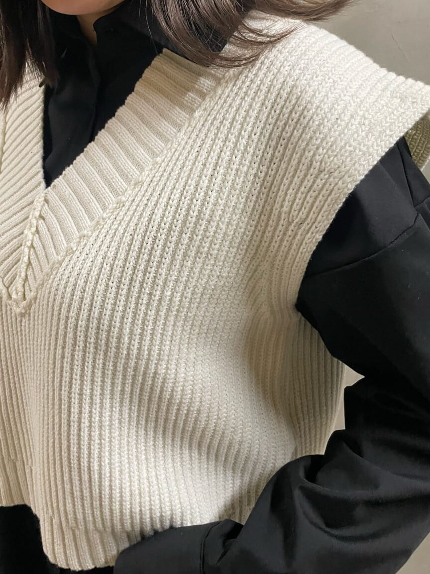 ホワイト系のブーツ、ブラック系のシャツ/ブラウス、ホワイト系のベストを着用したレディースの春コーディネートの3枚目の写真