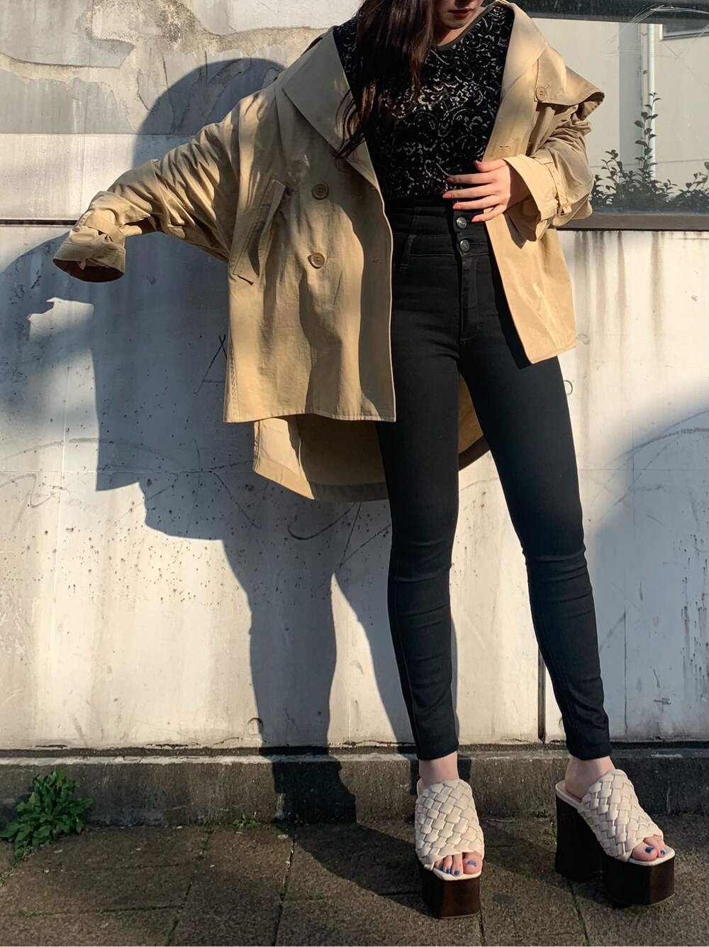 ベージュ系のトレンチコート、ホワイト系のサンダル、その他のニット/セーターを着用したレディースの春コーディネートの2枚目の写真