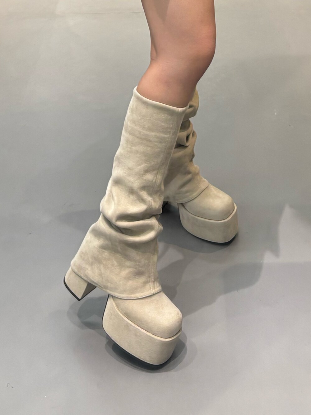 ホワイト系のブーツ、ブラック系のスカート、グレー系のニット/セーターを着用したレディースの秋コーディネートの5枚目の写真