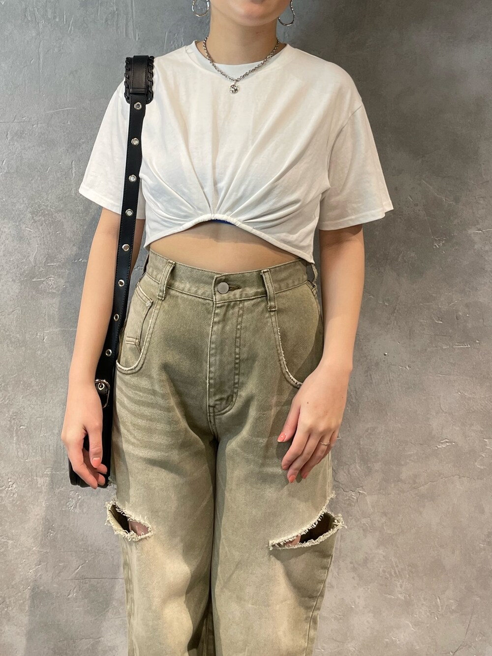 ベージュ系のデニムパンツ、グレー系のTシャツ/カットソー、ブラック系のショルダーバッグを着用したレディースの春コーディネートの4枚目の写真