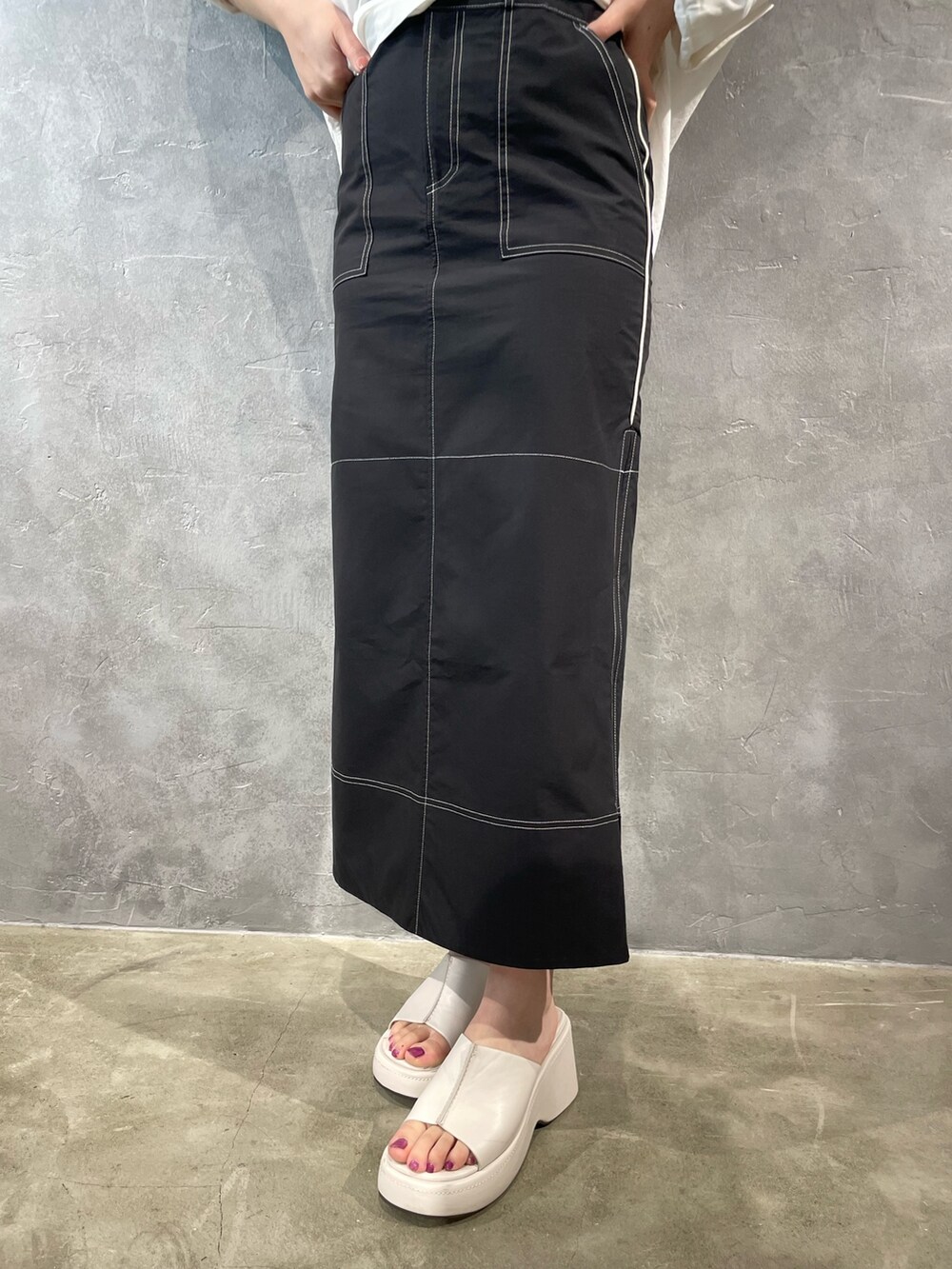 ホワイト系のサンダル、ホワイト系のキャミソール、ブラック系のスカートを着用したレディースの春コーディネートの7枚目の写真