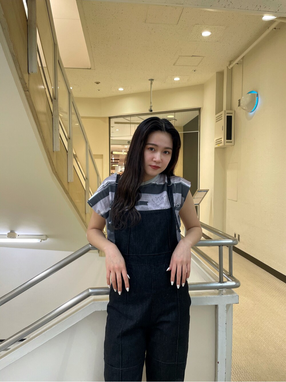 ホワイト系のサンダル、ブラック系のサロペット/オーバーオール、グレー系のTシャツ/カットソーを着用したレディースの春コーディネートの2枚目の写真