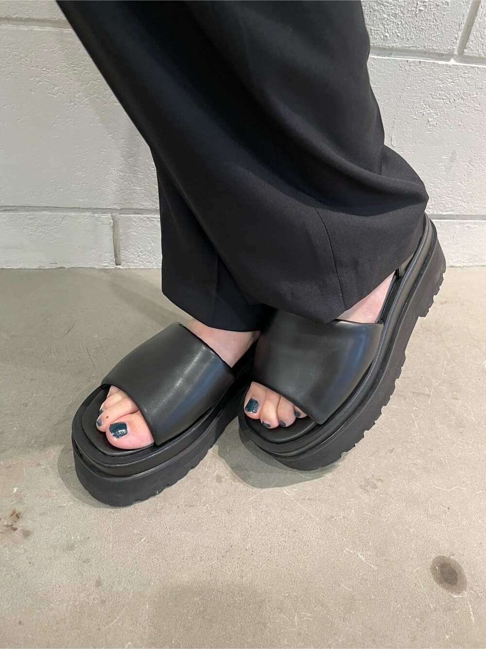 ブラック系のサンダル、ブラック系のスラックス、ブルー系のニット/セーターを着用したレディースの春コーディネートの8枚目の写真