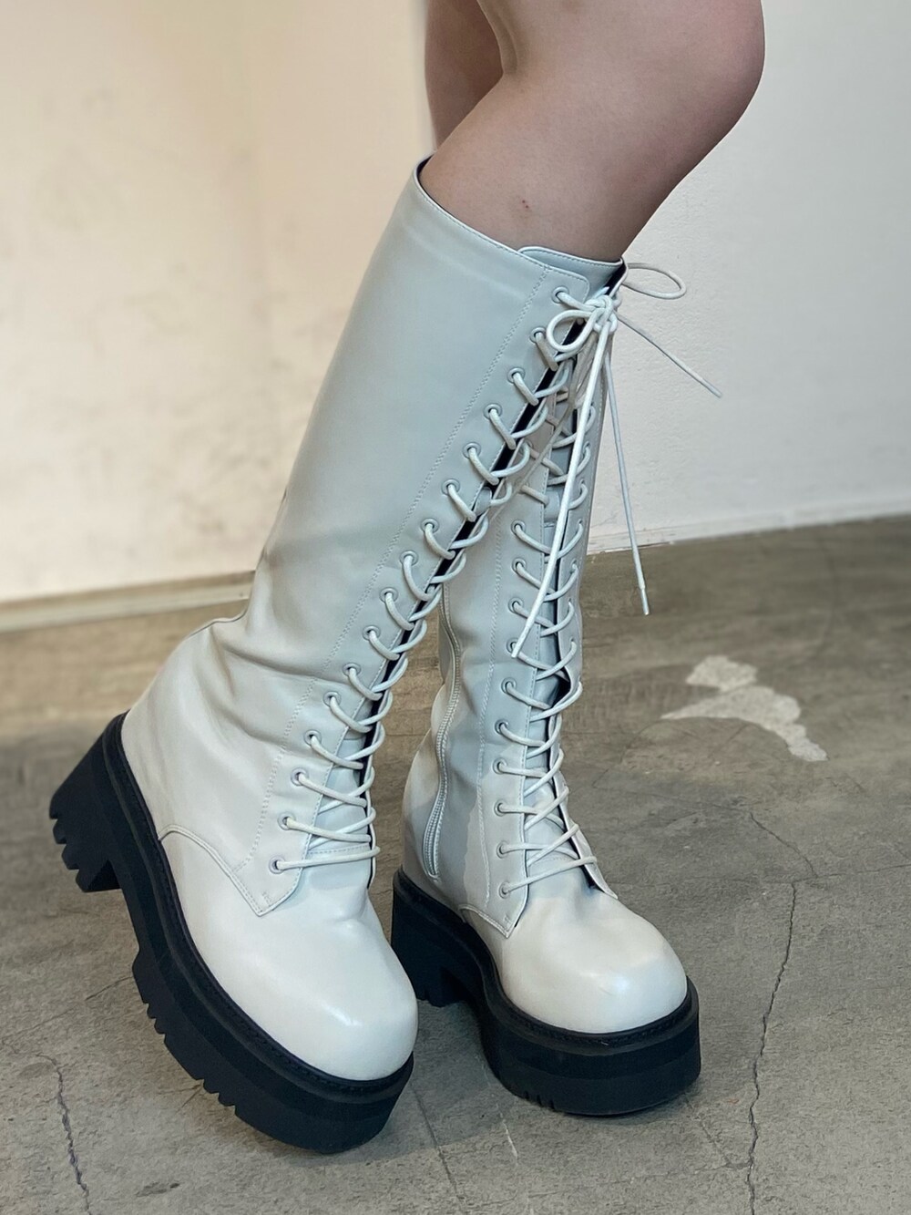 ホワイト系のスウェット、ホワイト系のブーツ、ブラック系のスカートを着用したレディースの冬コーディネートの6枚目の写真