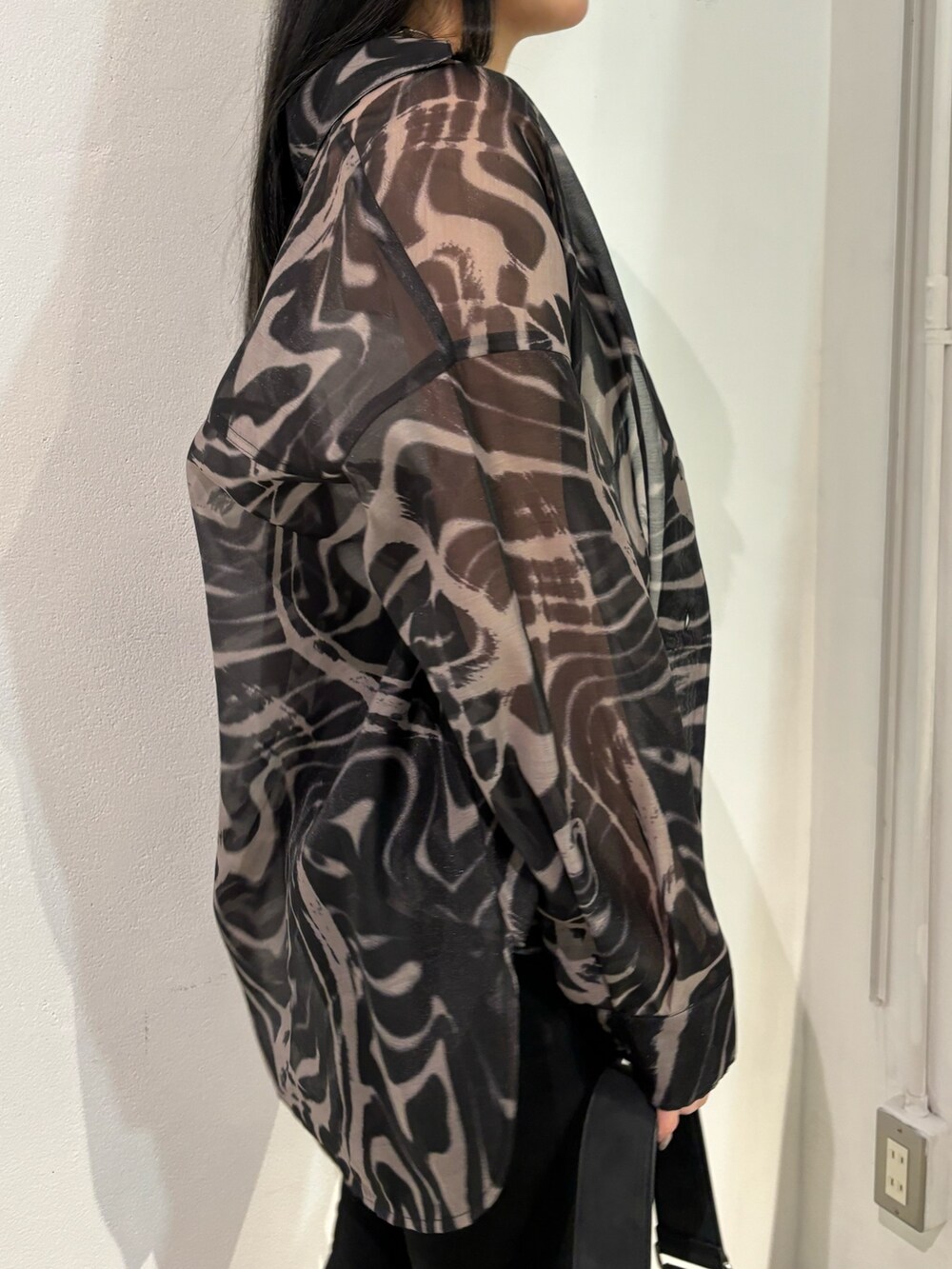 ブラック系のデニムパンツ、ベージュ系のシャツ/ブラウス、ブラック系のショルダーバッグを着用したレディースの春コーディネートの5枚目の写真