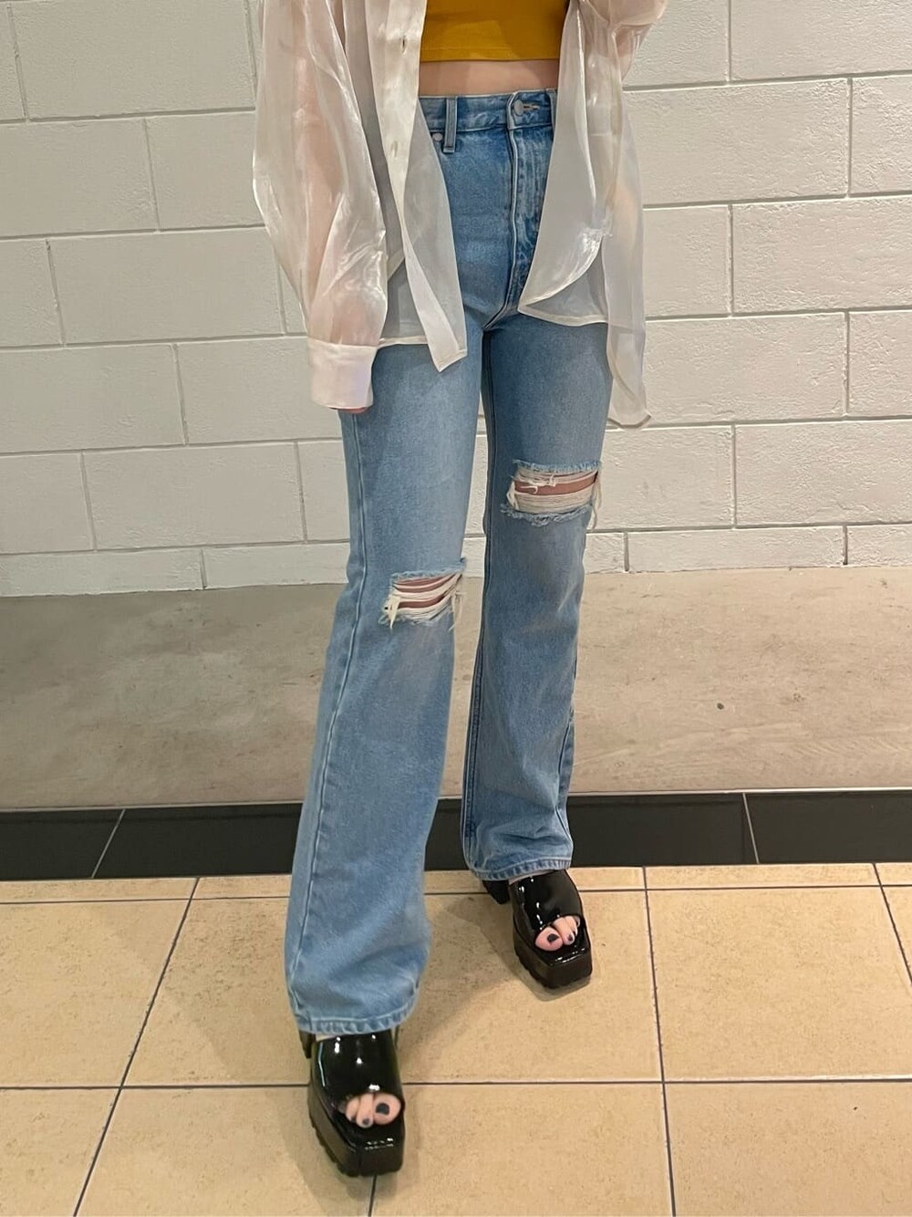 ブラック系のサンダル、ホワイト系のシャツ/ブラウス、ブルー系のデニムパンツを着用したレディースの春コーディネートの6枚目の写真