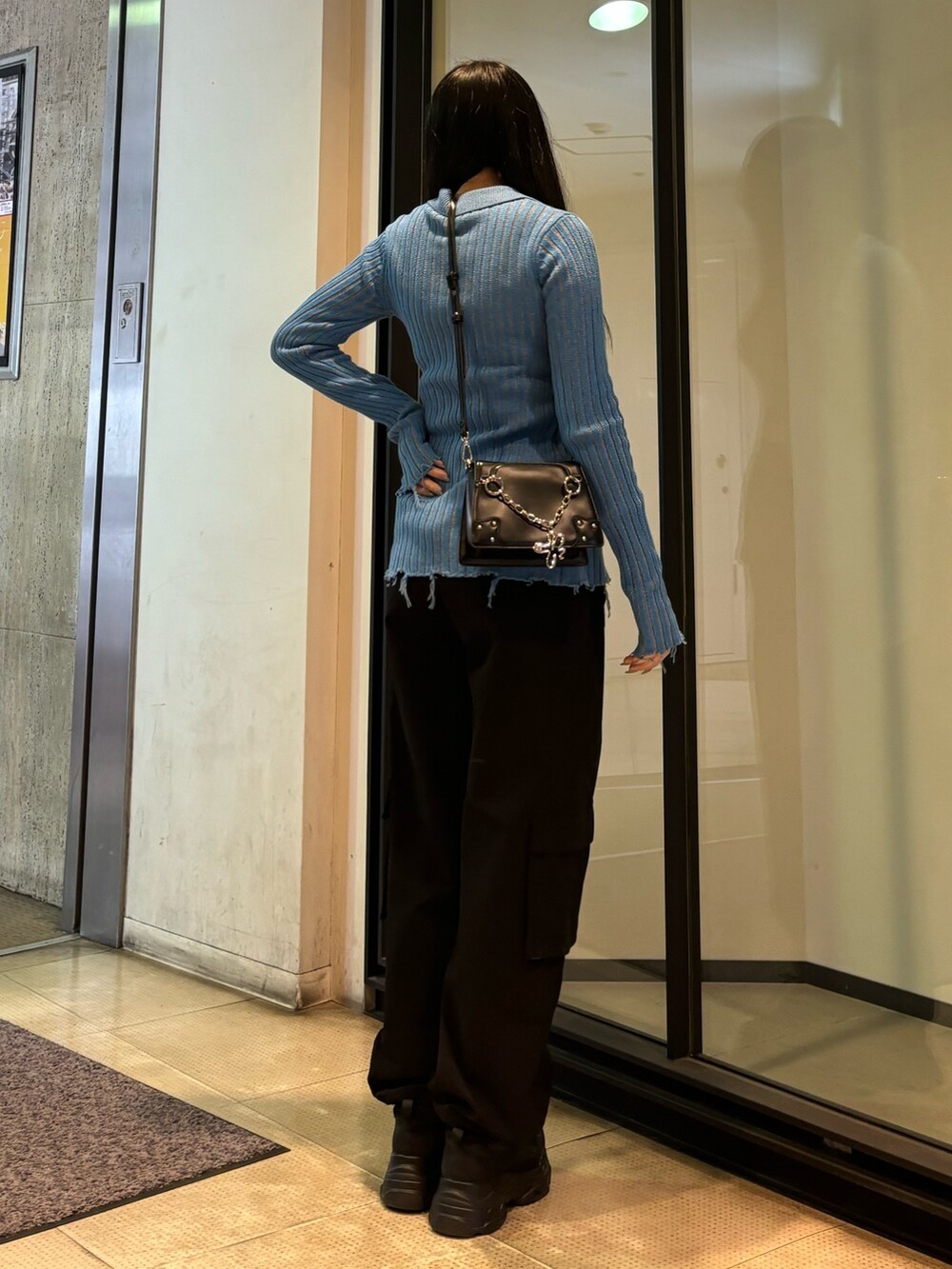 ブラック系のスニーカー、ブルー系のニット/セーター、ブラック系のその他パンツを着用したレディースの冬コーディネートの3枚目の写真