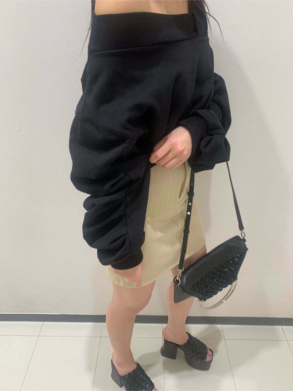 ブラック系のハンドバッグ、ブラック系のスウェット、ブラック系のサンダルを着用したレディースの春コーディネートの3枚目の写真