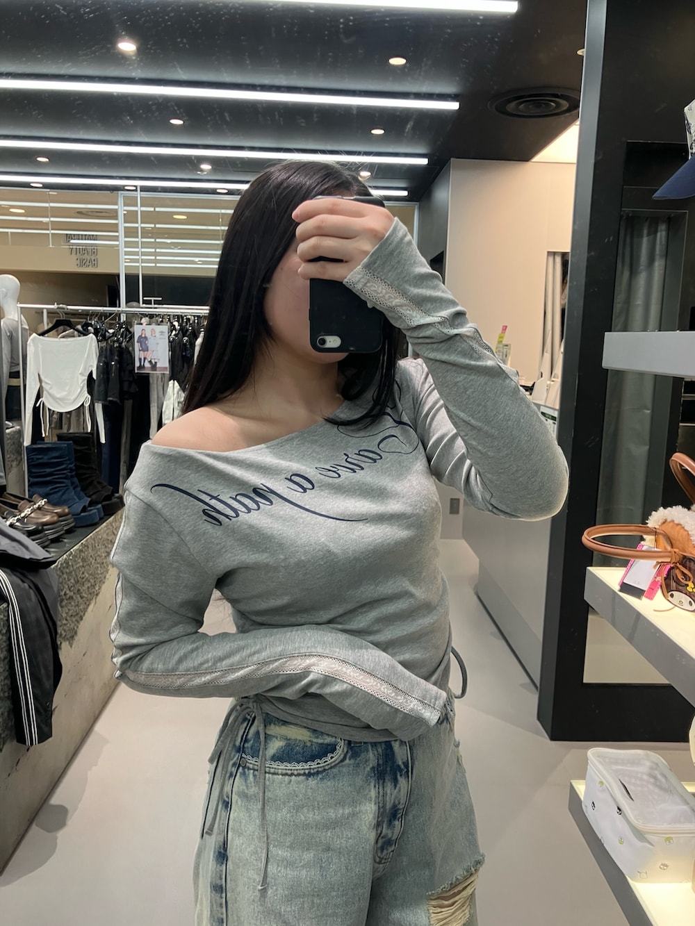 ブルー系のデニムパンツ、グレー系のTシャツ/カットソー、ブラック系のスニーカーを着用したレディースの春コーディネートの3枚目の写真