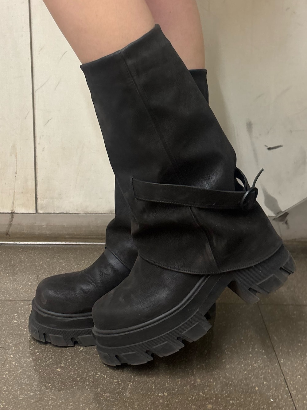 ブラック系のスカート、ブラック系のブーツ、ブラック系のハンドバッグを着用したレディースの春コーディネートの7枚目の写真