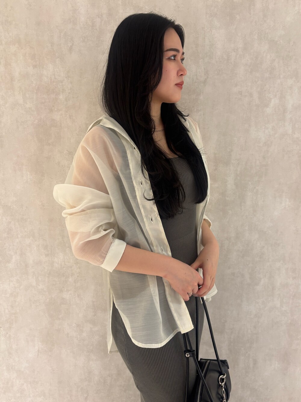 グレー系のサンダル、ブラック系のハンドバッグ、ブラック系のワンピースを着用したレディースの夏コーディネートの4枚目の写真