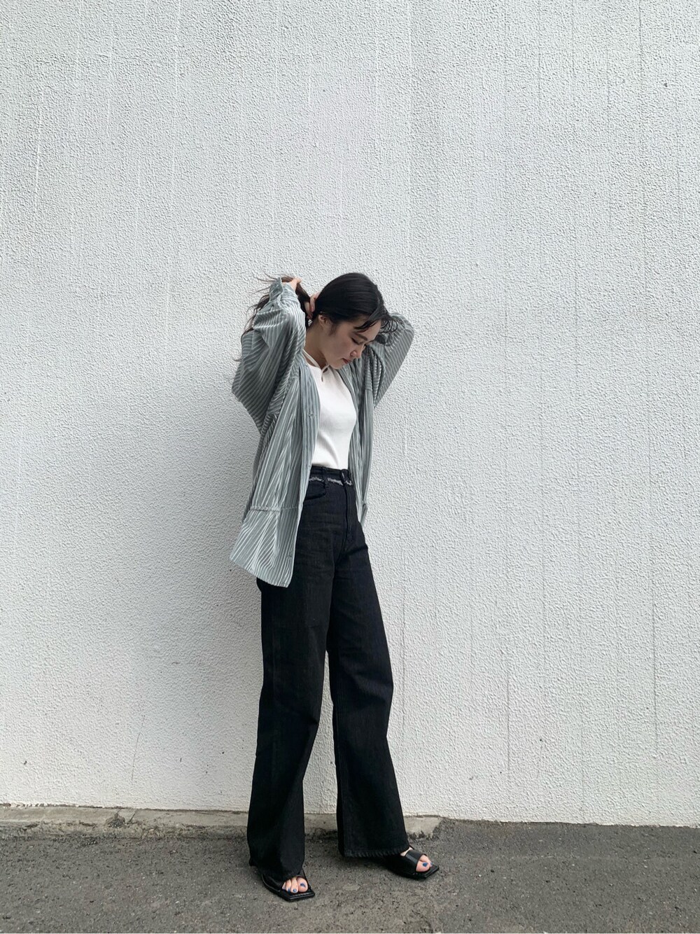 グリーン系のシャツ/ブラウス、ブラック系のサンダル、ブラック系のデニムパンツを着用したレディースの春コーディネートの3枚目の写真