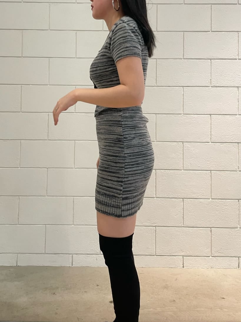 ブラック系のスカート、ブラック系のニット/セーター、ブラック系のブーツを着用したレディースの夏コーディネートの6枚目の写真